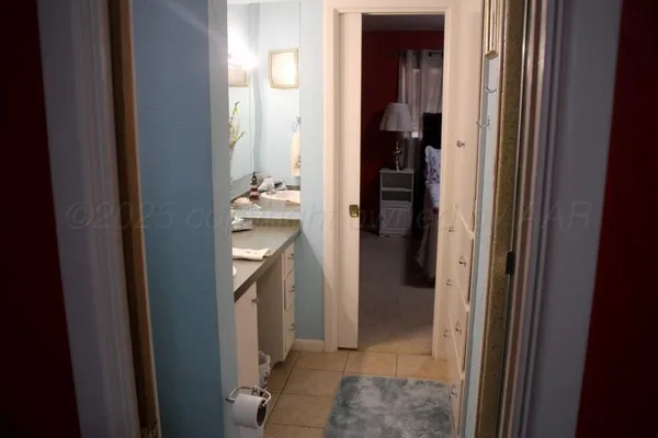 a bedroom with a bed and lamp on dresser