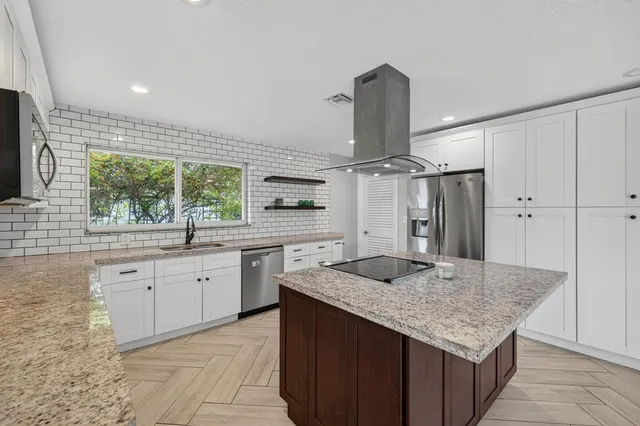 a kitchen with granite countertop cabinets a sink and stainless steel appliances