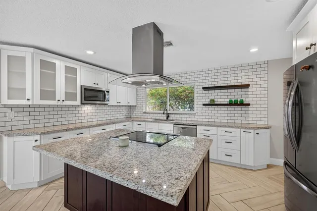 a kitchen with stainless steel appliances granite countertop a sink and a refrigerator