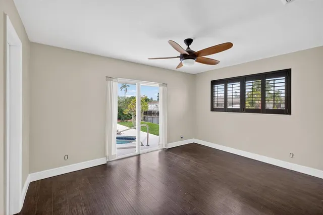 a view of wooden floor and a chandelier fan in a room