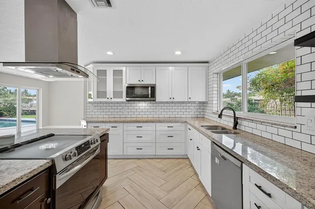 a kitchen with stainless steel appliances granite countertop a sink stove and refrigerator