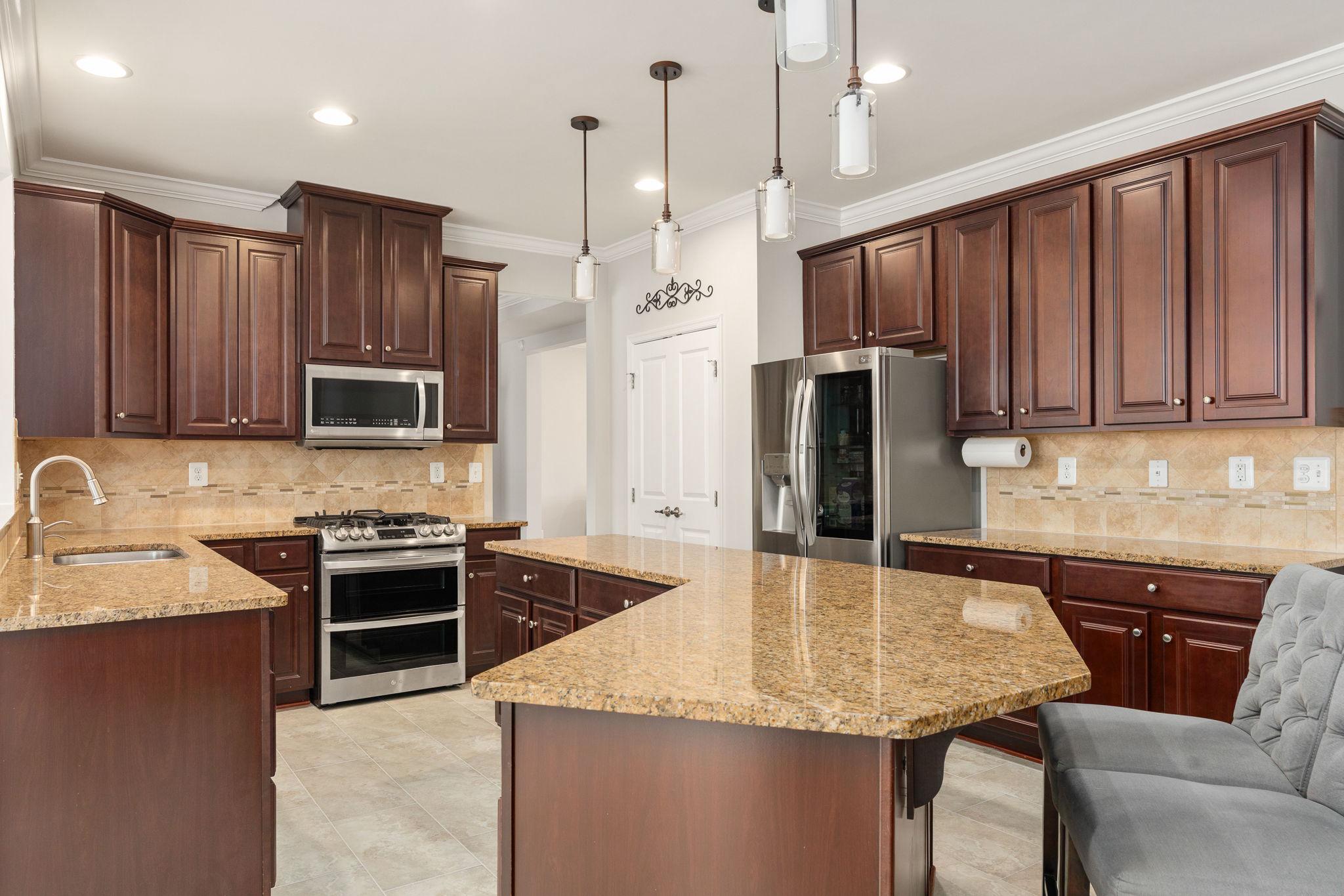 9417 Reservoir Road Fredericksburg, VA 22407 - Photo 16 of 76 a kitchen with stainless steel appliances granite countertop a sink refrigerator and cabinets