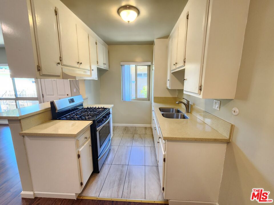 7925 Vineland Avenue, Unit 26 Los Angeles, CA 91352 - Photo 11 of 34 a kitchen that has a sink and a stove in it