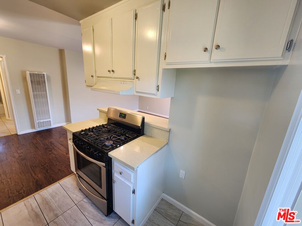 7925 Vineland Avenue, Unit 26 Los Angeles, CA 91352 - Photo 12 of 34 a kitchen with white cabinets and a stove