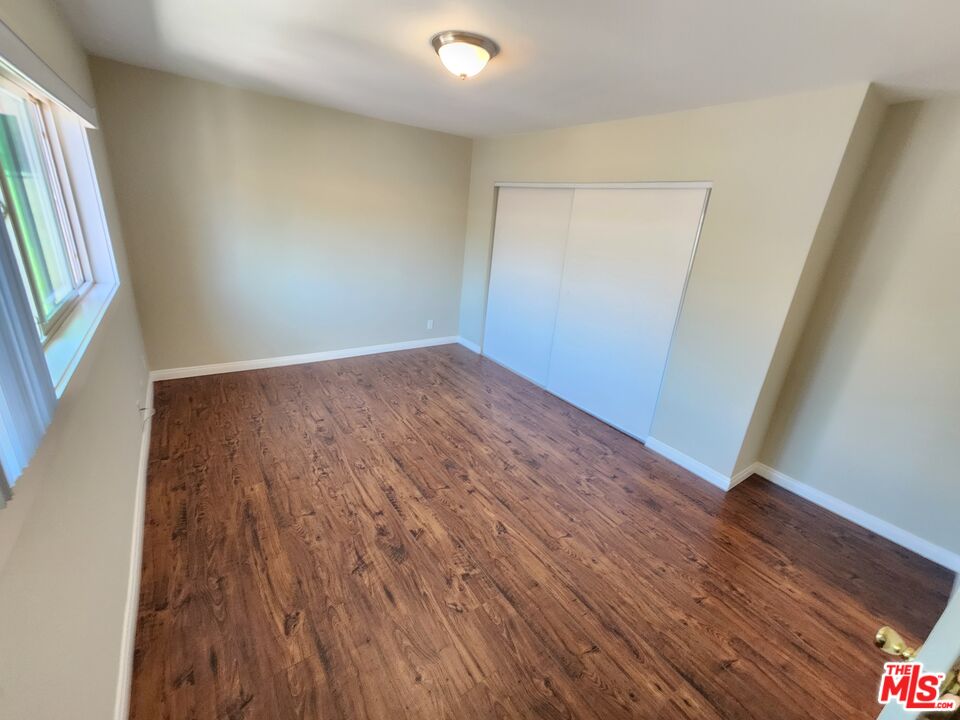 7925 Vineland Avenue, Unit 26 Los Angeles, CA 91352 - Photo 20 of 34 an empty room with wooden floor and windows