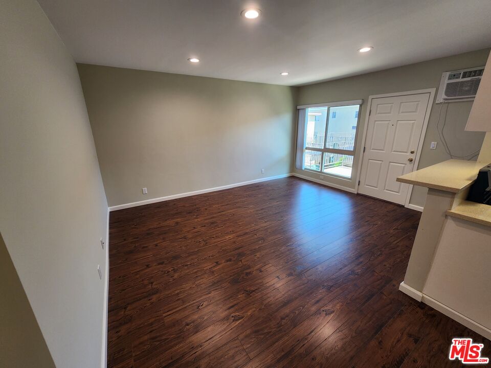 7925 Vineland Avenue, Unit 26 Los Angeles, CA 91352 - Photo 2 of 34 an empty room with wooden floor and windows