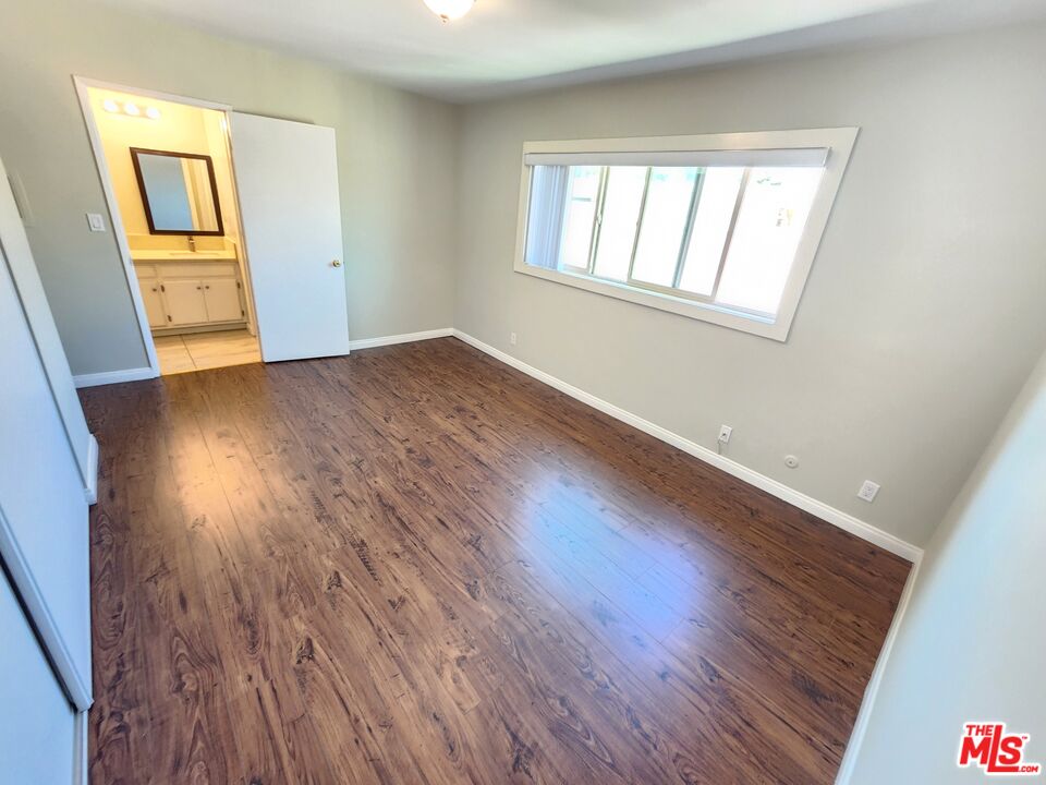 7925 Vineland Avenue, Unit 26 Los Angeles, CA 91352 - Photo 22 of 34 an empty room with wooden floor and windows