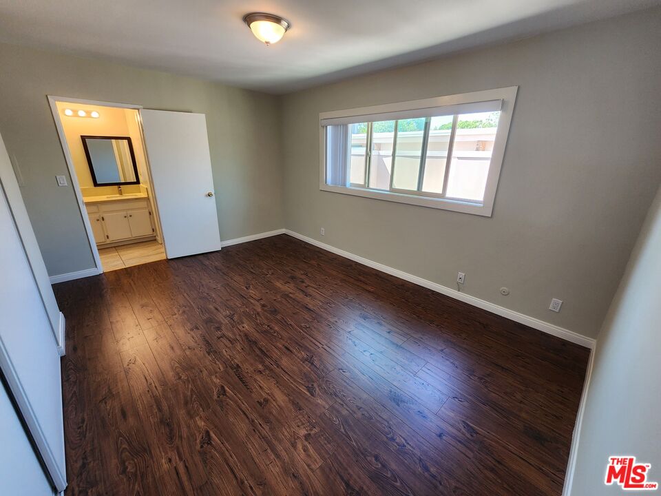 7925 Vineland Avenue, Unit 26 Los Angeles, CA 91352 - Photo 23 of 34 a view of an empty room with wooden floor and a window
