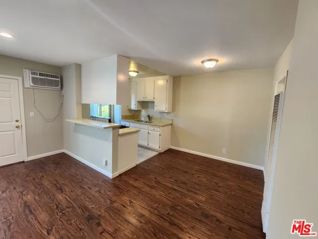 a kitchen with a sink cabinets and wooden floor
