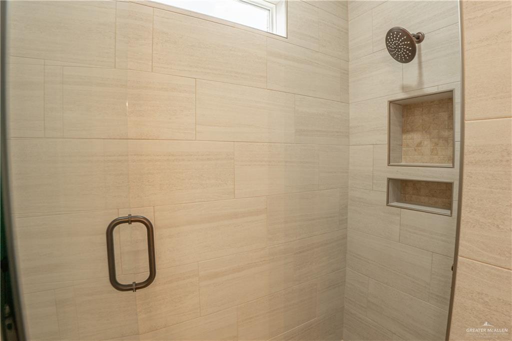 2618 Max Street Harlingen, TX 78552 - Photo 14 of 35 Tiled shower featuring a bronze shower head and two recessed niches