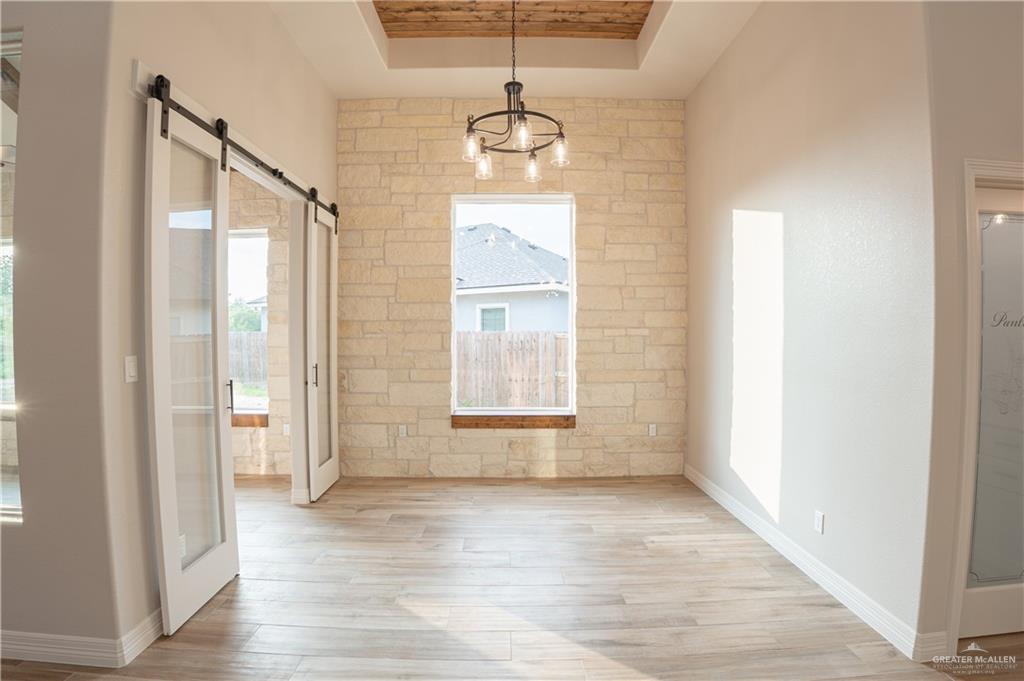 2618 Max Street Harlingen, TX 78552 - Photo 15 of 35 Spacious interior featuring a stone accent wall, wood-finish flooring, and a coffered ceiling with wood planking
