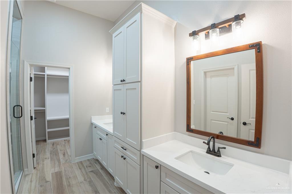 2618 Max Street Harlingen, TX 78552 - Photo 20 of 35 Dual white shaker vanities with integrated sinks, framed mirror, and wood-finish flooring