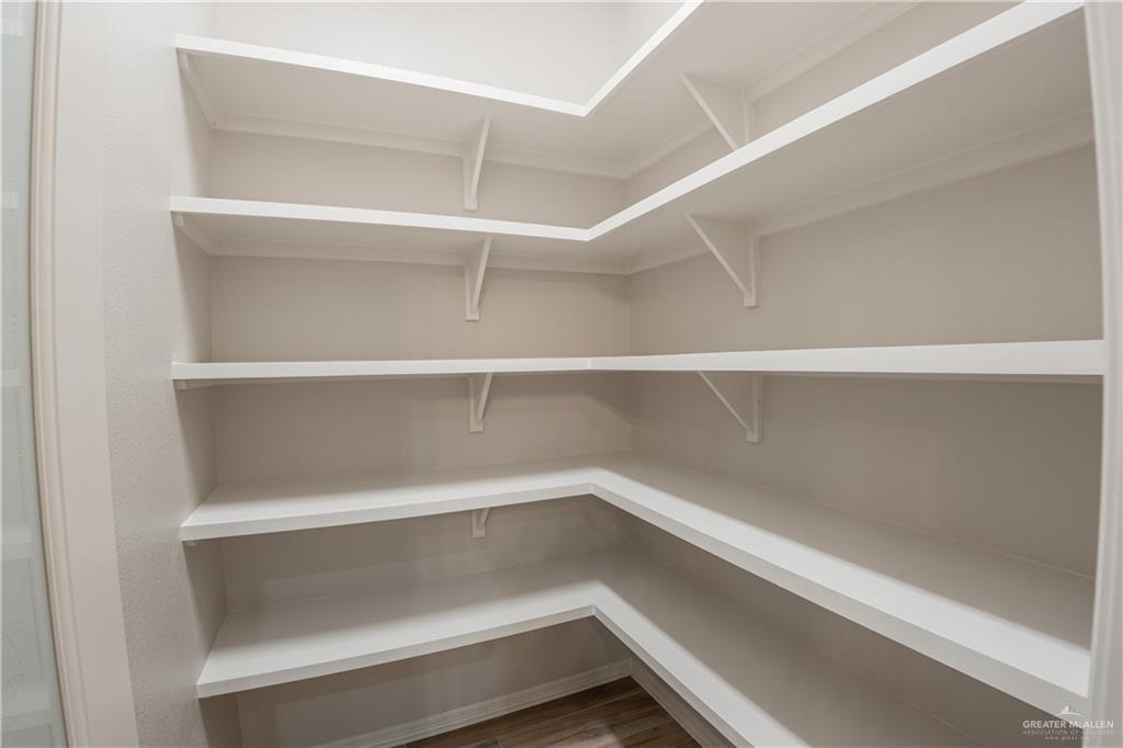 2618 Max Street Harlingen, TX 78552 - Photo 29 of 35 Spacious walk-in pantry featuring multiple levels of white shelving, ample storage, and wood-finish flooring