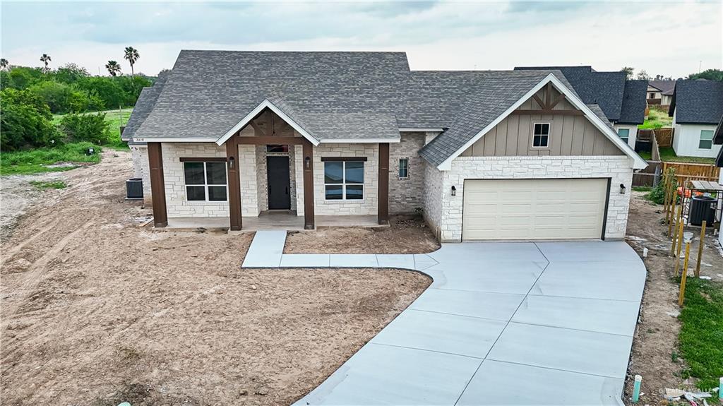 2618 Max Street Harlingen, TX 78552 - Photo 4 of 35 Stone and siding exterior with a dark-paneled garage door