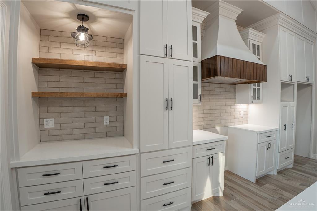 2618 Max Street Harlingen, TX 78552 - Photo 8 of 35 Kitchen featuring white shaker cabinetry, light brick-patterned backsplash, and wood-finish flooring