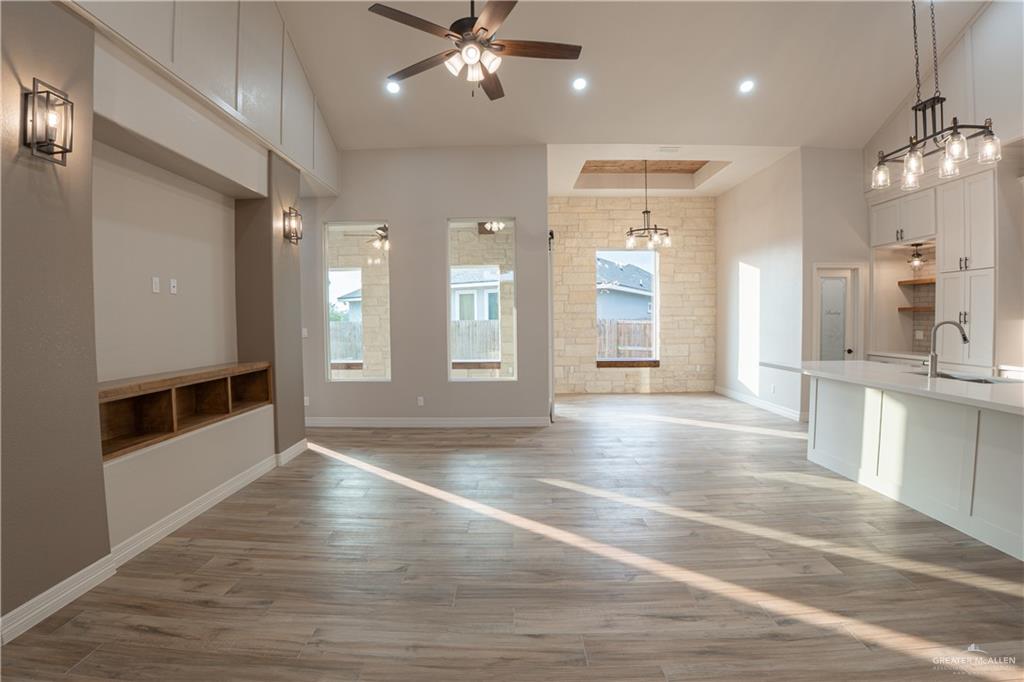 2618 Max Street Harlingen, TX 78552 - Photo 10 of 35 Spacious open-concept interior featuring wood-finish flooring, a built-in media console with shelving, and high ceilings with recessed lighting