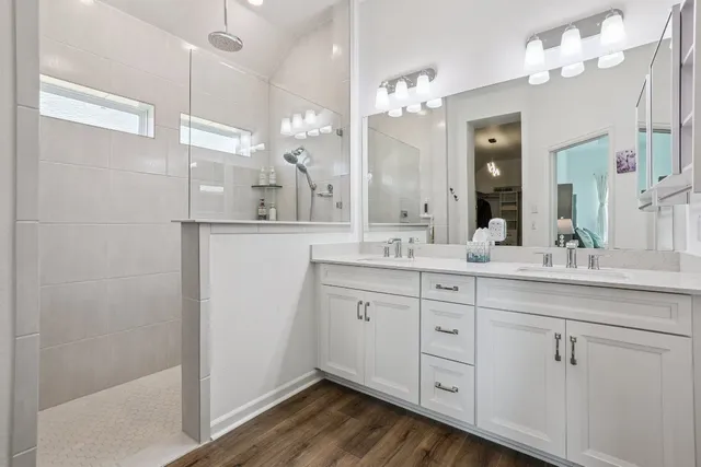 a spacious bathroom with a granite countertop sink a mirror and a shower