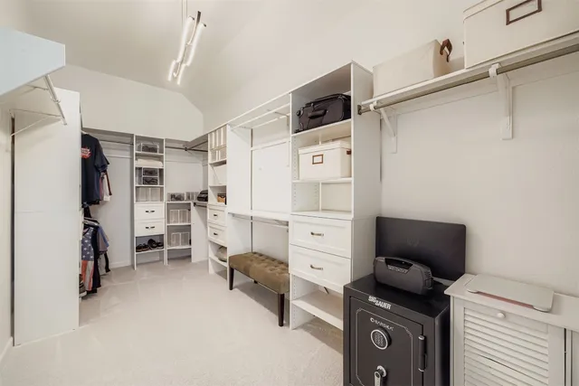 a view of walk in closet with clothes and shoes