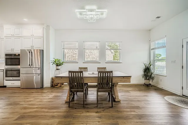 a view of a a dining room with furniture window and wooden floor