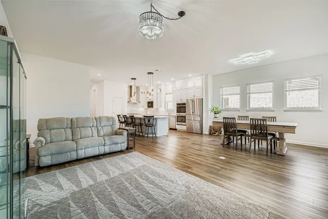 a living room with furniture wooden floor and kitchen view