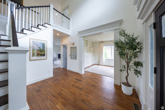 868 Braddock Lane Alpine, UT 84004 - Photo 8 of 64 Grand entry foyer featuring wood-finish flooring, a prominent staircase with dark treads and white risers, and a two-story ceiling