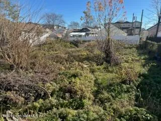 a view of a yard with wooden fence
