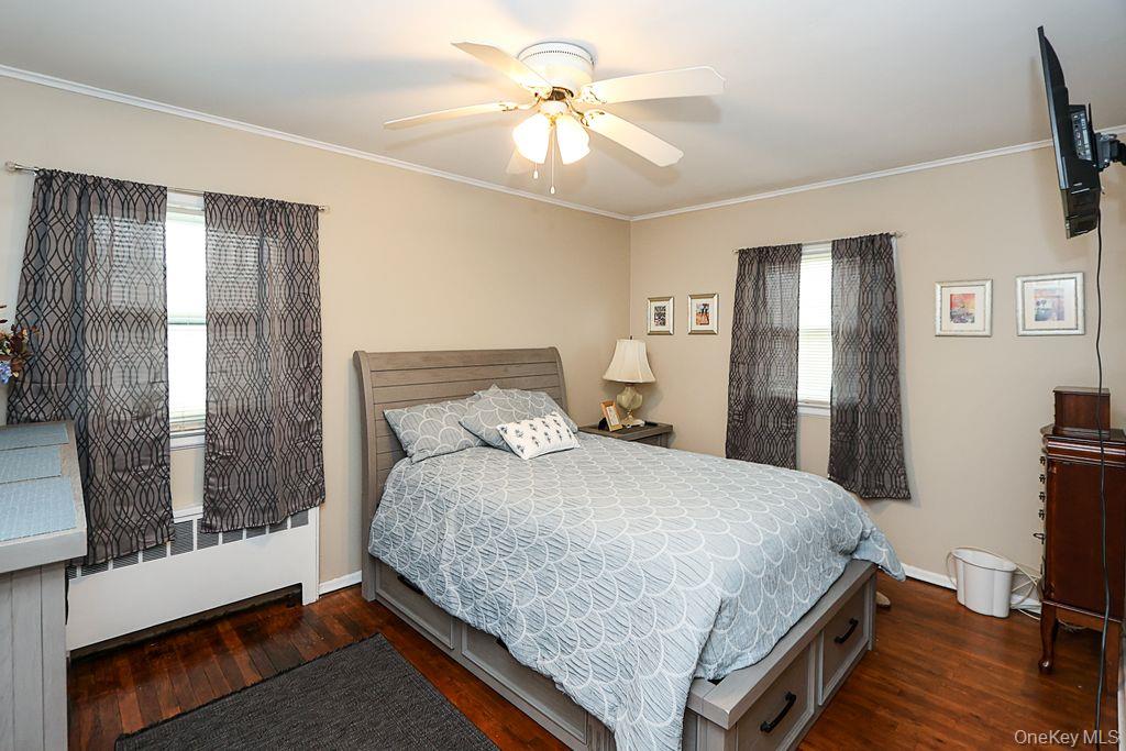 64 Conlon Road Roosevelt, NY 11575 - Photo 12 of 19 a bedroom with a bed and a chandelier