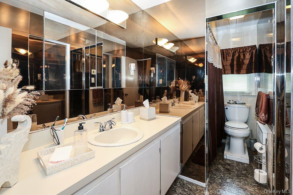 64 Conlon Road Roosevelt, NY 11575 - Photo 13 of 19 a bathroom with a sink double vanity and a toilet