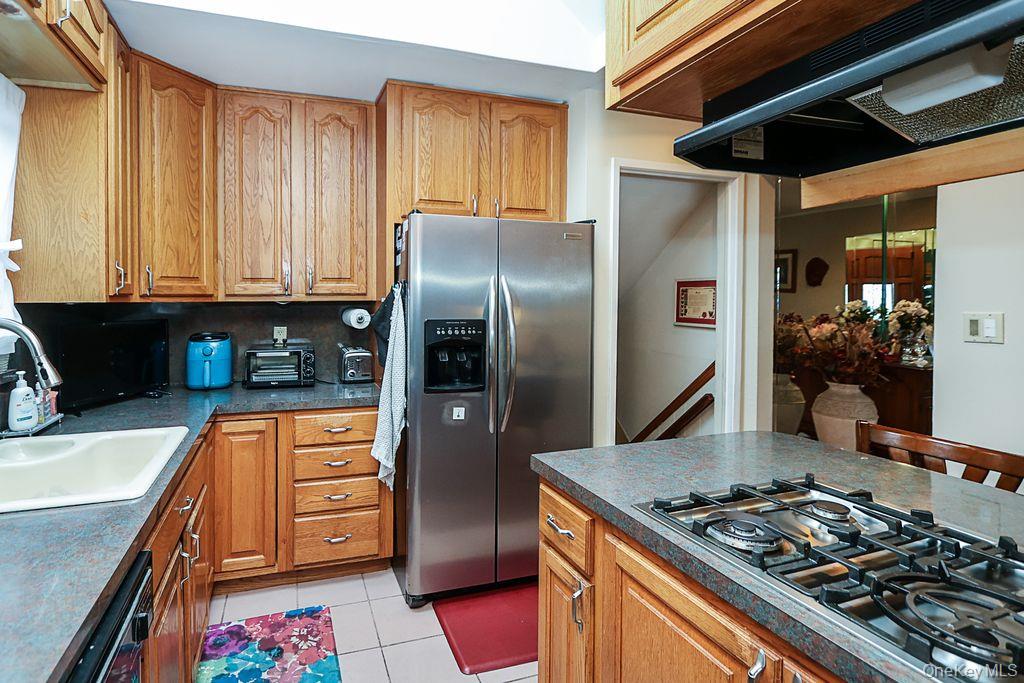 64 Conlon Road Roosevelt, NY 11575 - Photo 8 of 19 a kitchen with stainless steel appliances granite countertop a refrigerator and a sink