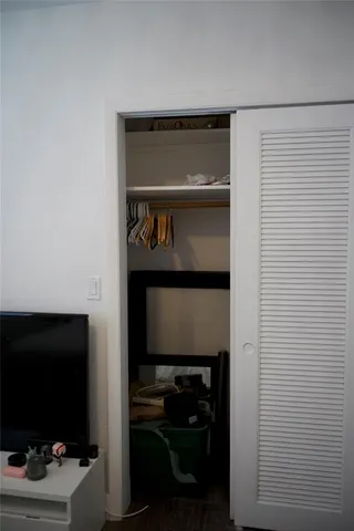 a room with a flat screen tv and a view of door