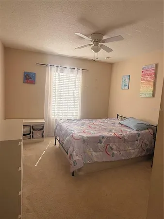 a spacious bedroom with a bed and a chandelier