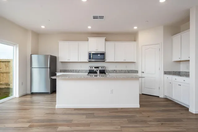 a kitchen with refrigerator cabinets and wooden floor