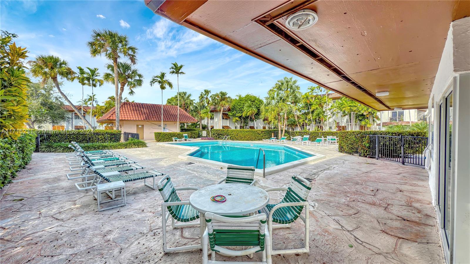 9302 Southwest 77th Avenue, Unit B1 Miami, FL 33156 - Photo 13 of 17 a view of a backyard with table and chairs potted plants