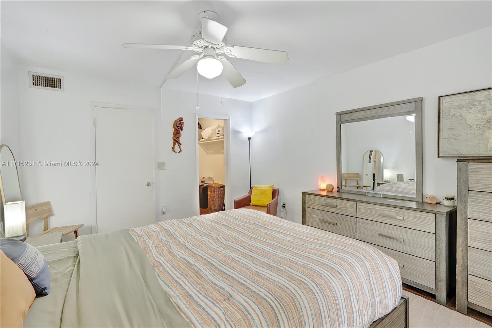 9302 Southwest 77th Avenue, Unit B1 Miami, FL 33156 - Photo 7 of 17 a bedroom with a bed and a chandelier