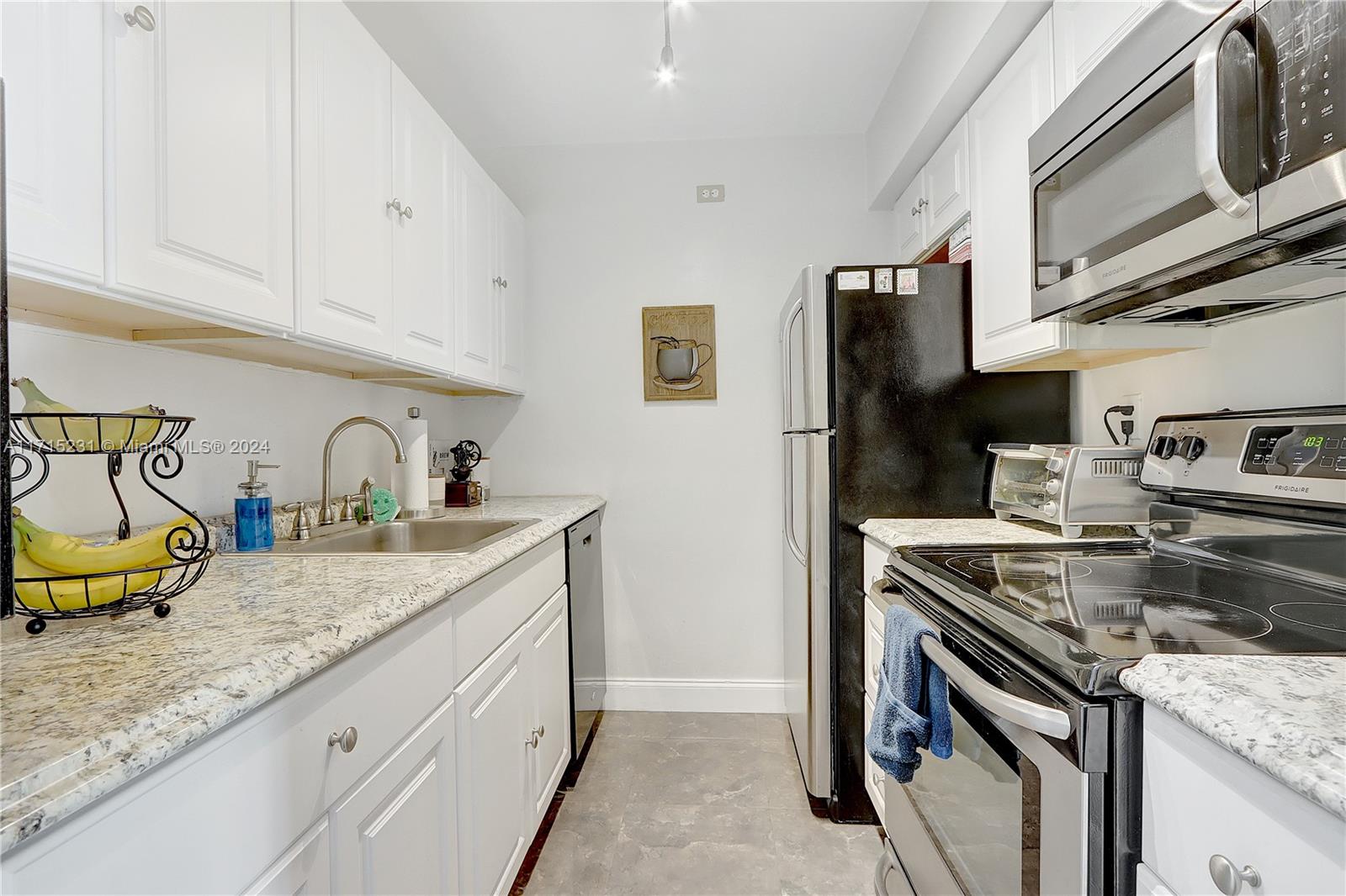 9302 Southwest 77th Avenue, Unit B1 Miami, FL 33156 - Photo 8 of 17 a kitchen with stainless steel appliances granite countertop a sink stove and refrigerator