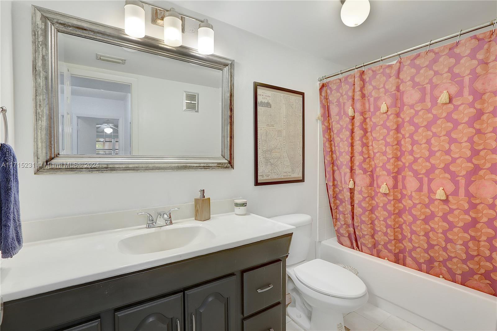 9302 Southwest 77th Avenue, Unit B1 Miami, FL 33156 - Photo 9 of 17 a bathroom with a sink a toilet and shower curtain
