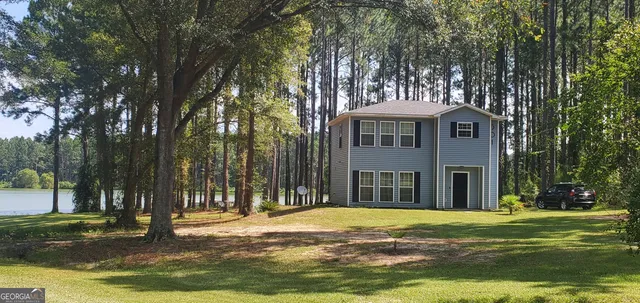 a view of a house with a yard in a forest