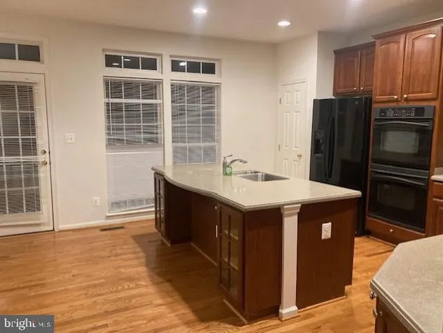 a kitchen with kitchen island granite countertop a sink and a refrigerator