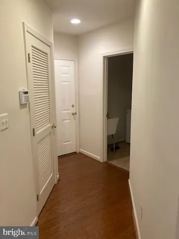 a view of a hallway with closet and bathroom