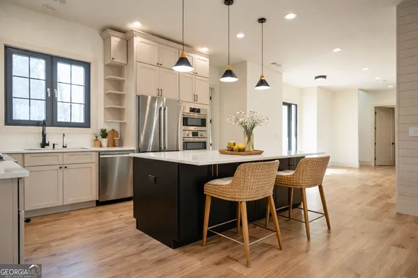 a kitchen with a table chairs sink and cabinets