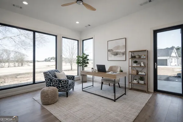 a living room with furniture and large windows