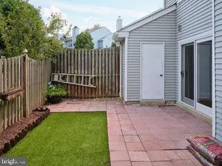 a view of a house with a small yard and wooden fence