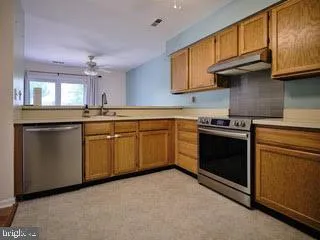 a kitchen with granite countertop cabinets stainless steel appliances and a sink