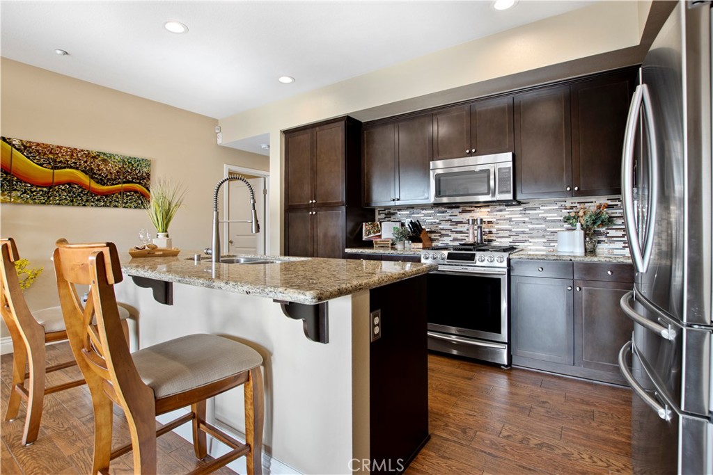 a kitchen with kitchen island granite countertop a sink appliances cabinets and furniture