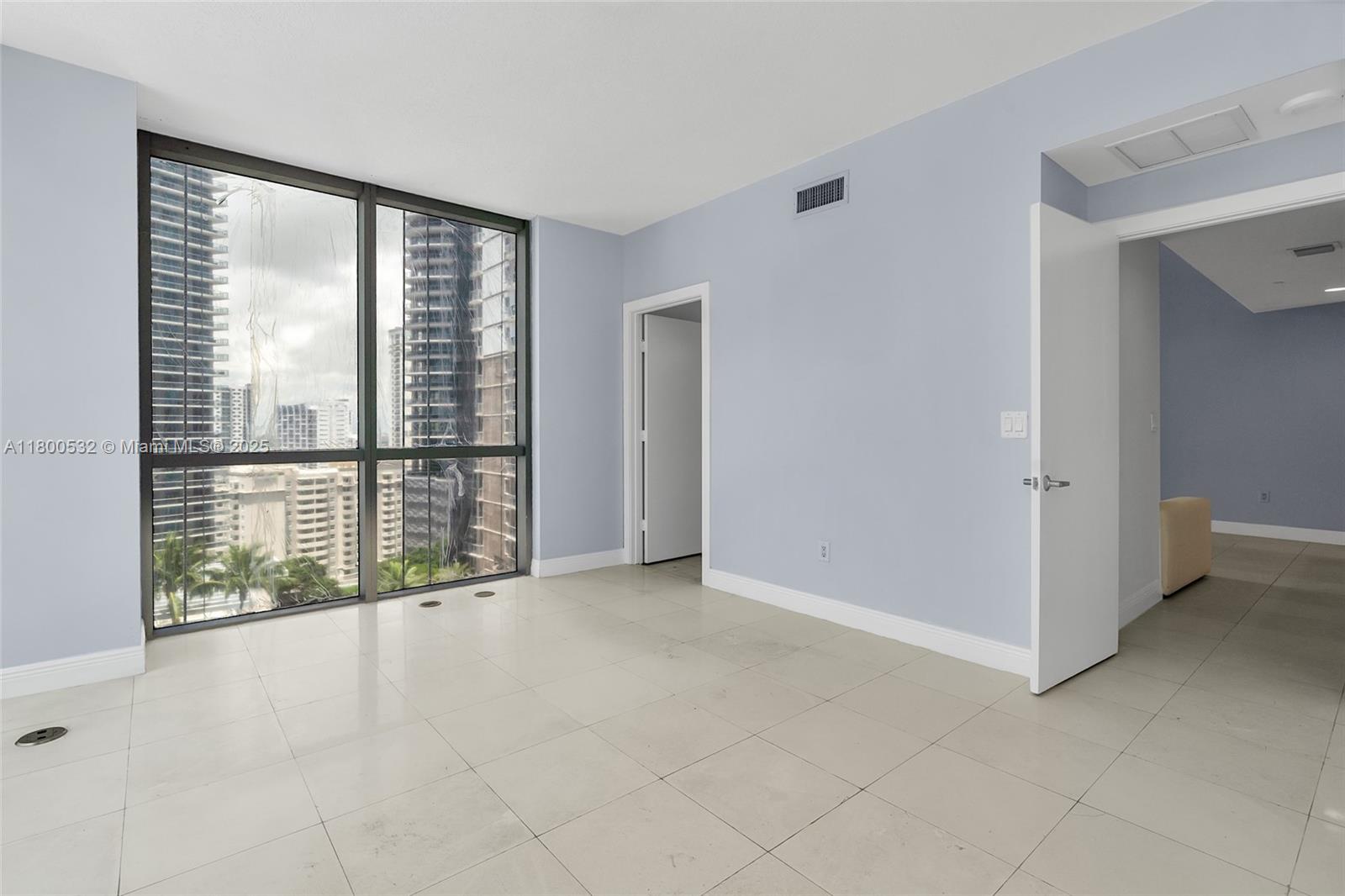 1060 Brickell Avenue, Unit 1811 Miami, FL 33131 - Photo 4 of 43 an empty room with windows and city view