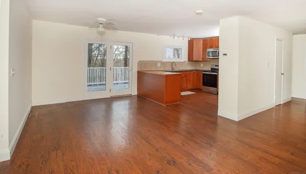 a view of kitchen with stainless steel appliances granite countertop a stove top oven a sink with wooden floors