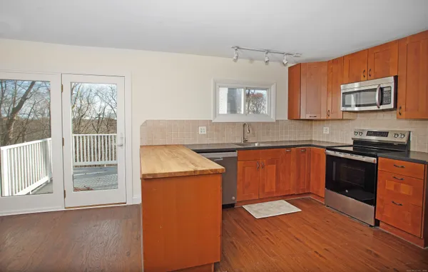 a kitchen with granite countertop a stove a sink and a microwave