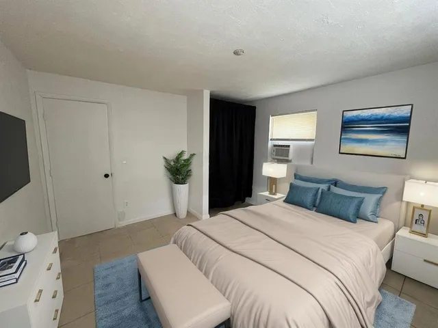 a bedroom with a bed and a potted plant