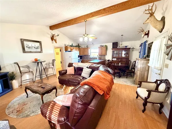 a living room with furniture kitchen view and a chandelier
