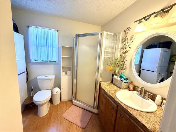 a bathroom with a granite countertop toilet sink and mirror